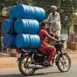 Unique way to carry drums on a bike: Woman loads blue drums by seating an old man, video leaves people astonished!